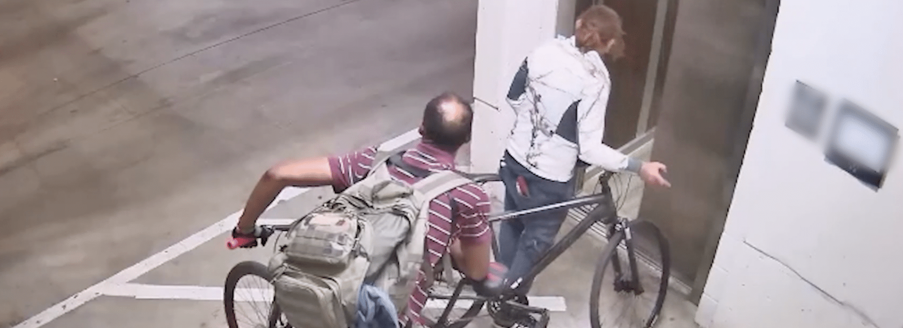 Two people on bikes sneak into parking garage